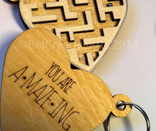 Load image into Gallery viewer, Valentine&#39;s Day gift, heart-shaped wooden maze puzzle with metal bead and clear acrylic top, with attached metal ring and colorful tassel by @belcreativearts
